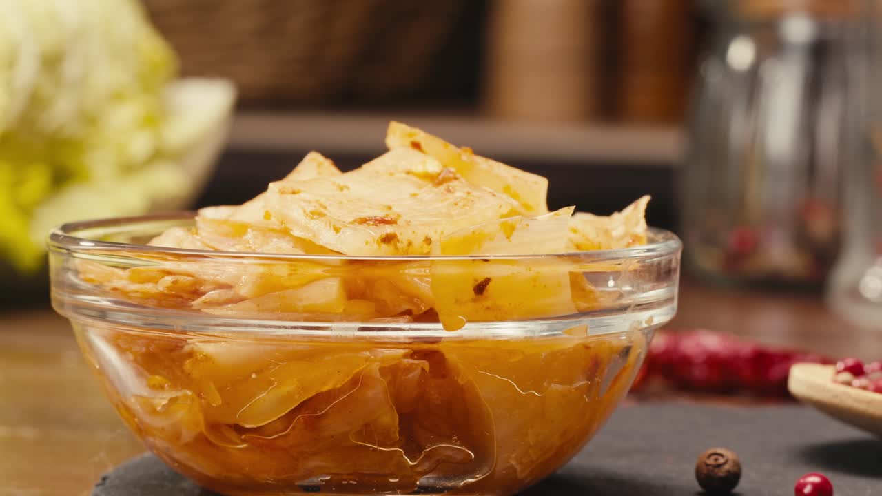 Fermented spicy cabbage kimchi with on plate close-up. Preservation of vegetables in glass jars. Fermentation preserved kimchi cabbage with spices macro. Asian cuisine.
