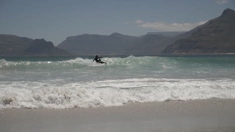 cámara lenta de surfistas a lo largo de la costa en sudáfrica