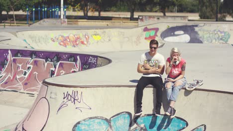 young couple sitting on a wall at a skate park