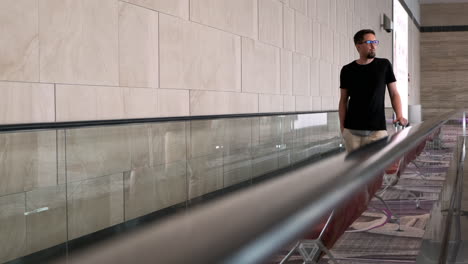 hombre caminando por una escalera mecánica del aeropuerto