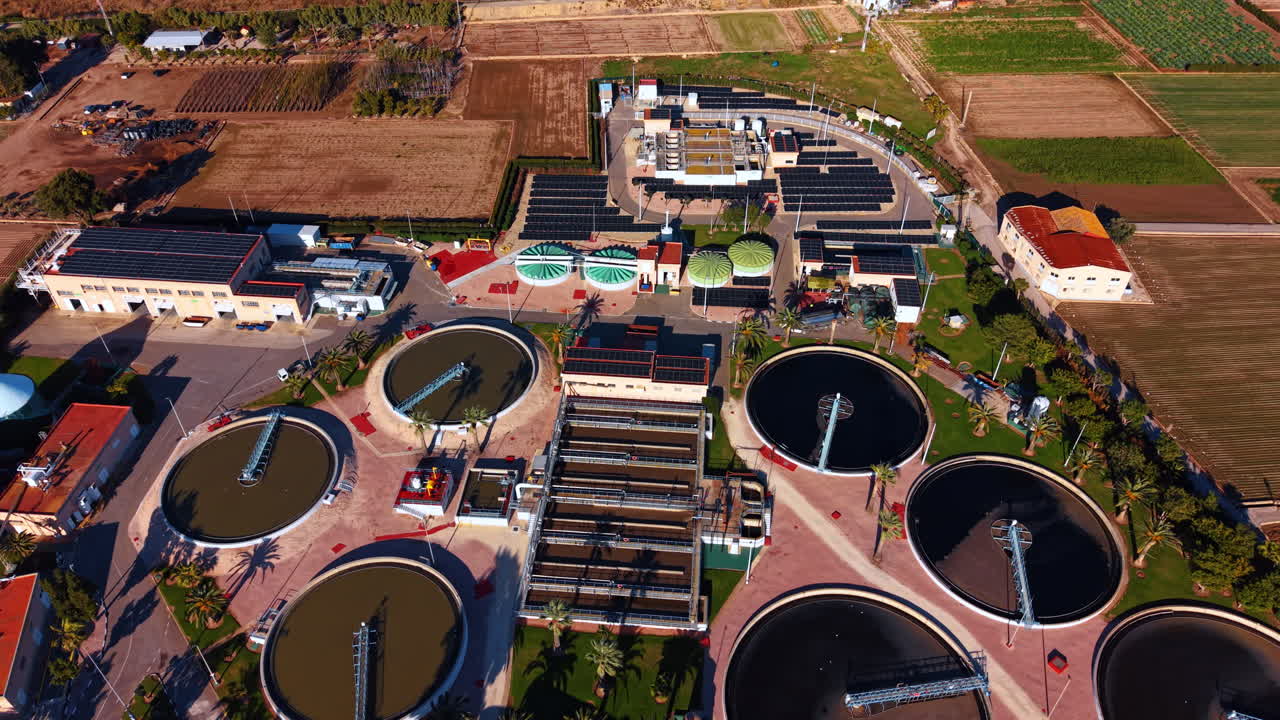 Industrial water purification tanks and filters. Elevated view of circular and rectangular tanks at a water treatment plant integrated with renewable energy systems