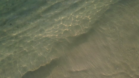 vista superior aérea, tiro giratorio medio del mar, regazo de una pequeña ola tropical en una playa