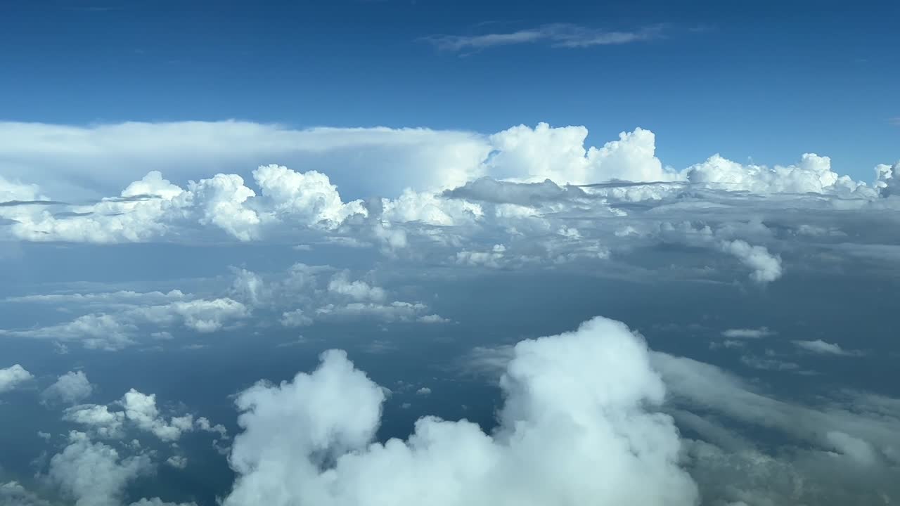 흰 구름과 거대한 적란운 버스가 앞에 있는 동안 제트기 조종석에서 공중 보기