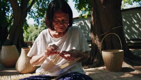 woman weaving baskets outdoors