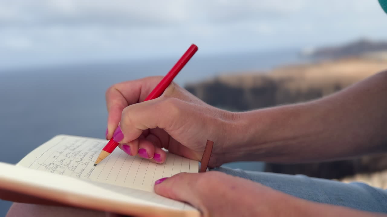 Writing in a notebook with ocean view