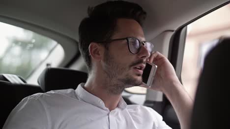 hombre de negocios usando un teléfono en un coche