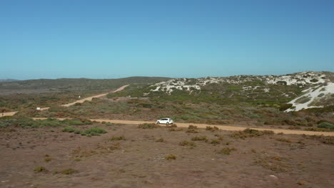 Coche-Que-Viaja-A-Través-Del-Paisaje-Natural-En-El-Parque-Nacional-De-La-Costa-Oeste,-Sudáfrica