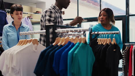 employee showing black shirt to couple