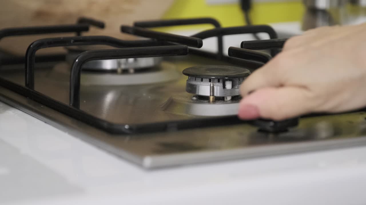 부 가스 비에 불을 켜는 여성 손. 불타는 가스 버너의 근접.