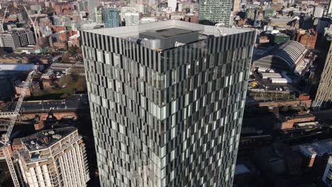 Aerial-drone-flight-heading-away-from-the-South-Towers-rooftop-to-reveal-the-surrounding-buildings-and-a-view-of-Manchester-City-Centre