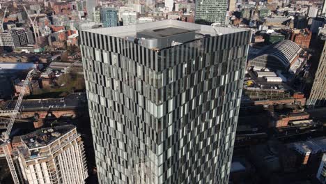 aerial drone flight heading away from the south towers rooftop to reveal the surrounding buildings and a view of manchester city centre