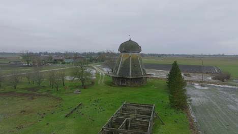 beautiful aerial establishing view of old wooden windmill in the middle of the field, prenclavu windmill , overcast winter day, wide drone point of shot