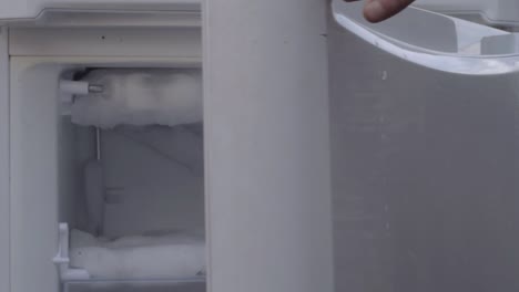 opening door of an empty refrigerator freezer compartment