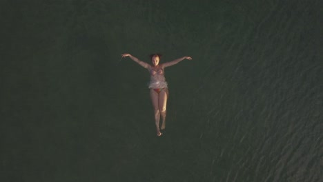 mujer nadando en la espalda en el mar aéreo