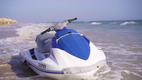 slow-motion-shot-of-a-speedboat-on-the-coast-on-a-sunny-day,-waves-crashing