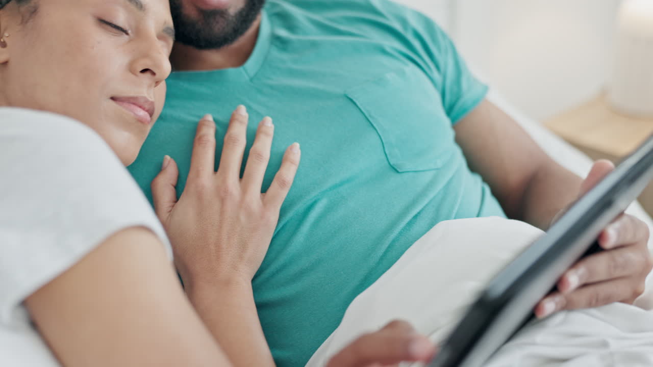 pareja, abrazo y relajarse con la tableta en la cama