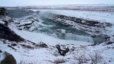 plano general estático en la cima de la montaña que muestra la cascada de gullfoss que fluye en invierno - islandia, europa