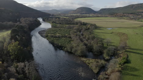 Vista-Aérea-Volando-Sobre-El-Río-Dee-Hacia-Ballater-En-El-Parque-Nacional-De-Cairngorms-En-Un-Día-Soleado,-Aberdeenshire