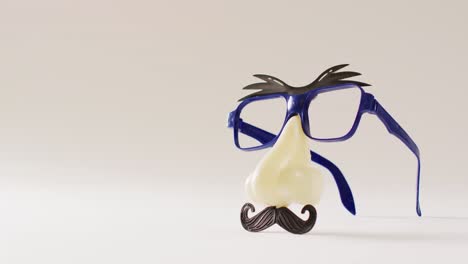 vídeo de cejas de plástico adjuntas, gafas, nariz y bigote sobre fondo blanco con espacio para copiar