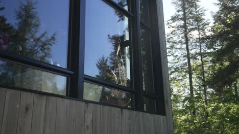 reflection on glass wall of person with hammock inside the zoobox at the vertendre in eastman, quebec canada