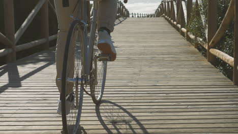 bike wheels close up on a boardwalk towards the beach