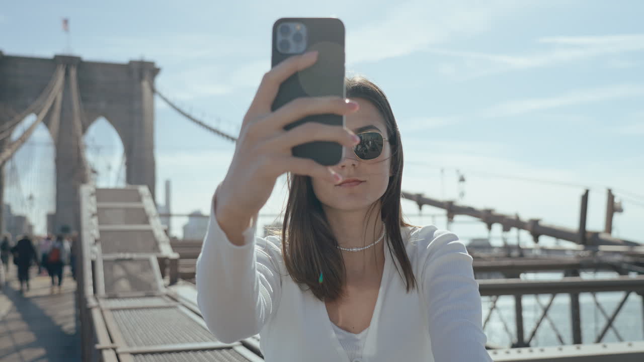 Woman taking a selfie on the Brooklyn Bridge