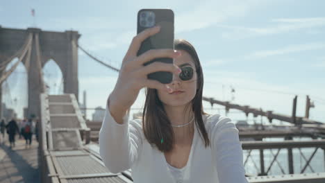 woman taking a selfie on the brooklyn bridge