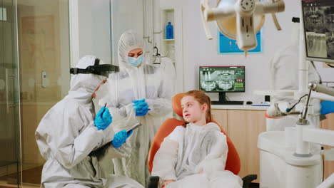 Médico-Dentista-En-Mono-Hablando-Con-Una-Paciente-Antes-Del-Examen