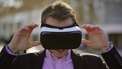 smiling young man taking off vr glasses