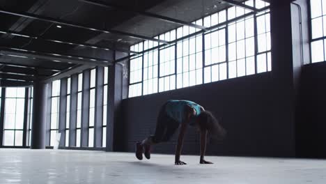 mujer afroamericana haciendo ejercicios de salto en un edificio urbano vacío