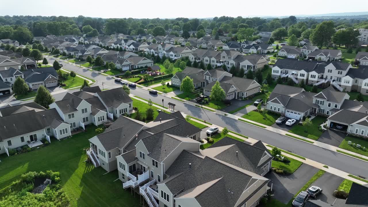 Luxury single-family homes in modern style in upscale neighborhood of USA. Similar houses in Suburb district at sunlight. Aerial zoom wide shot. Quiet serene atmosphere at sunset