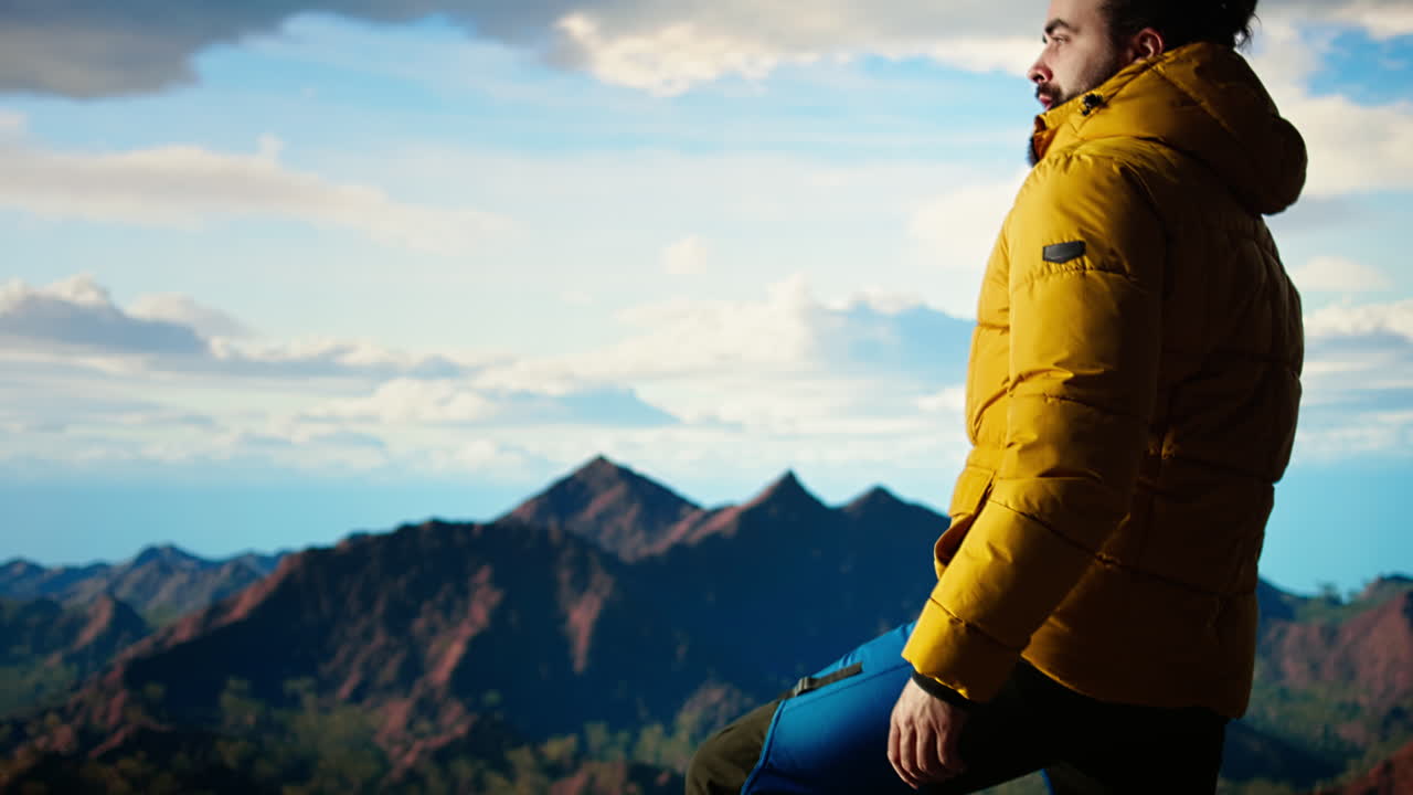 결단력 있는 등반자는 산과 광활한 하늘의 경치에 감탄하기 위해 잠시 멈니다.