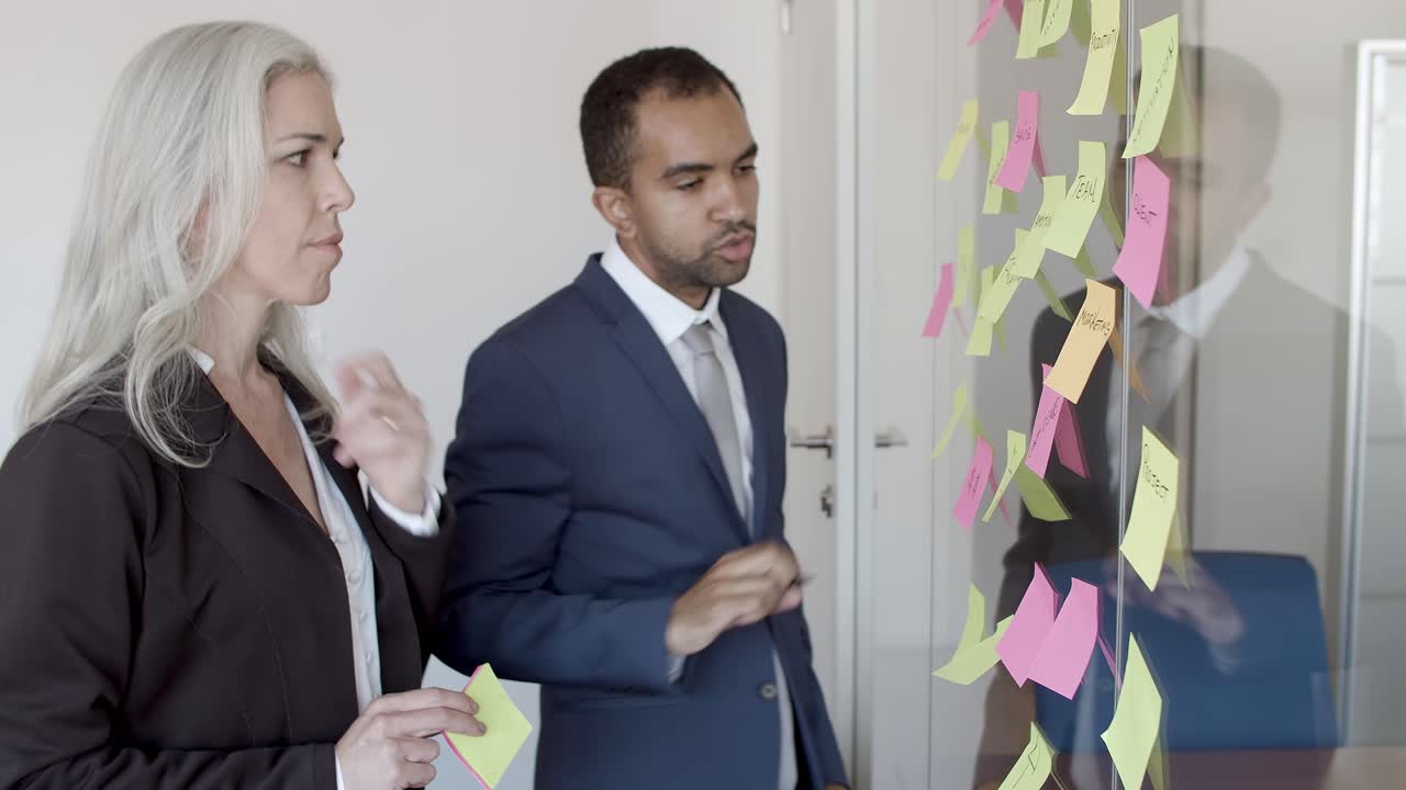 Male manager presenting project plan to nodding female boss