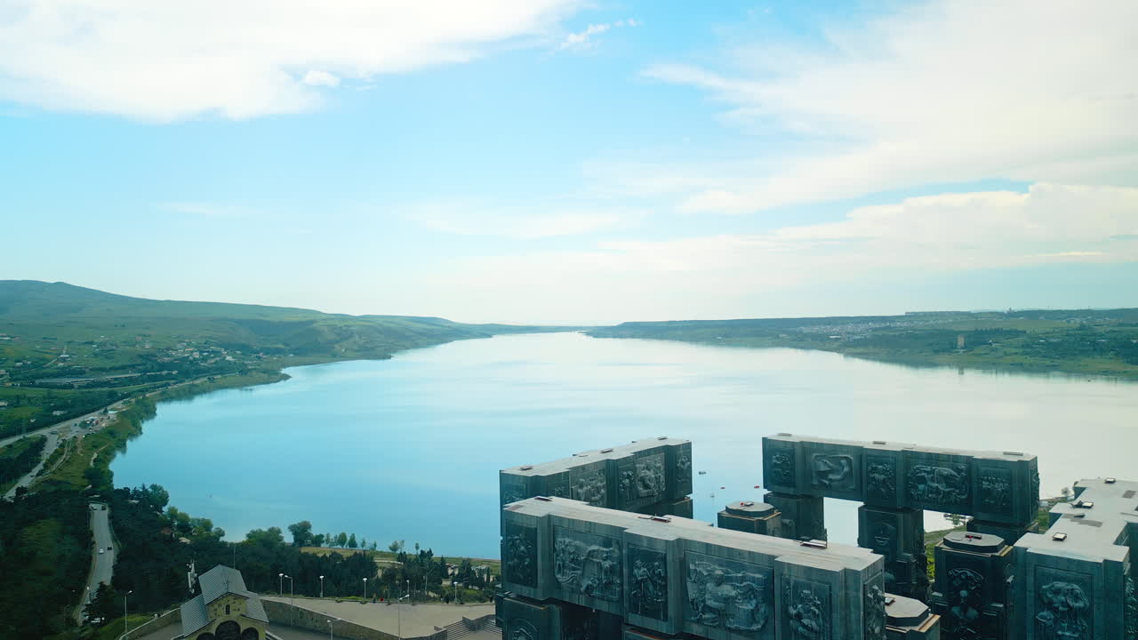 The Chronicle of Georgia monument overlooking the Tbilisi Sea reservoir, with visitors and cars