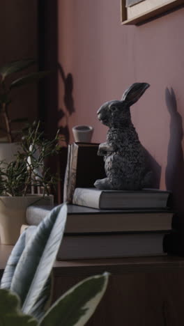 rabbit figurine on bookshelf with shadow