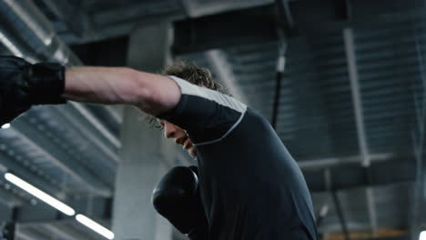 emotional fighter hitting boxing bag in fitness center. kickboxer boxing at gym