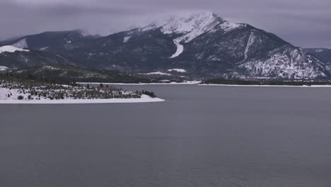 Lago-Dillon-Calma-Descongelado-Hielo-Centro-De-La-Ciudad-Frisco-Colorado-Aéreo-Cinemático-Drone-Nublado-Nevado-Invierno-Mañana-Vista-Breckenridge-Keystone-Silverthorne-Alcance-De-Diez-Millas-Adelante-Revelar