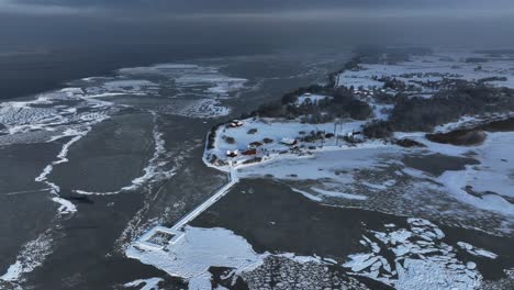 vista panorámica de la estación de anillo de pájaros en el cabo de vente y el muelle que conduce a la laguna de curonian en invierno cuando todo está congelado y cubierto de nieve