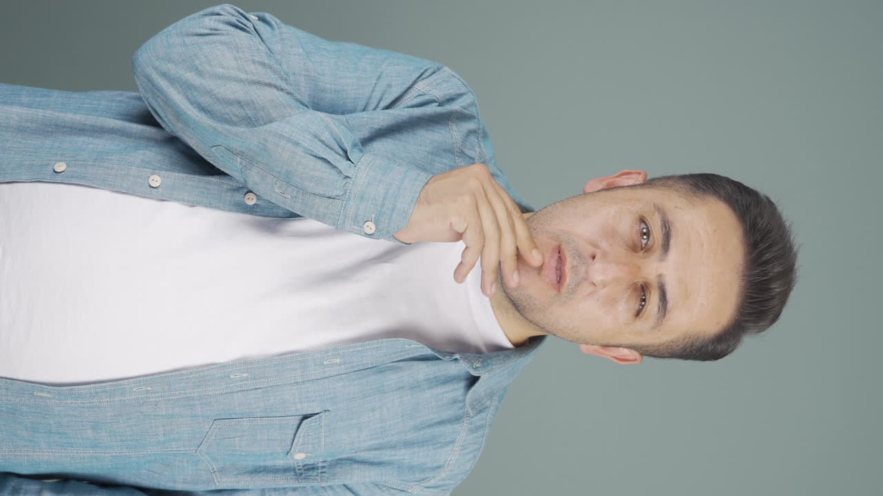 el video vertical de un hombre pensativo hacia la cámara viene con una idea.