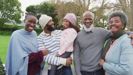 video of happy african american parents holding daughter in garden with grandparents