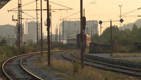 train approaching railway station at sunset