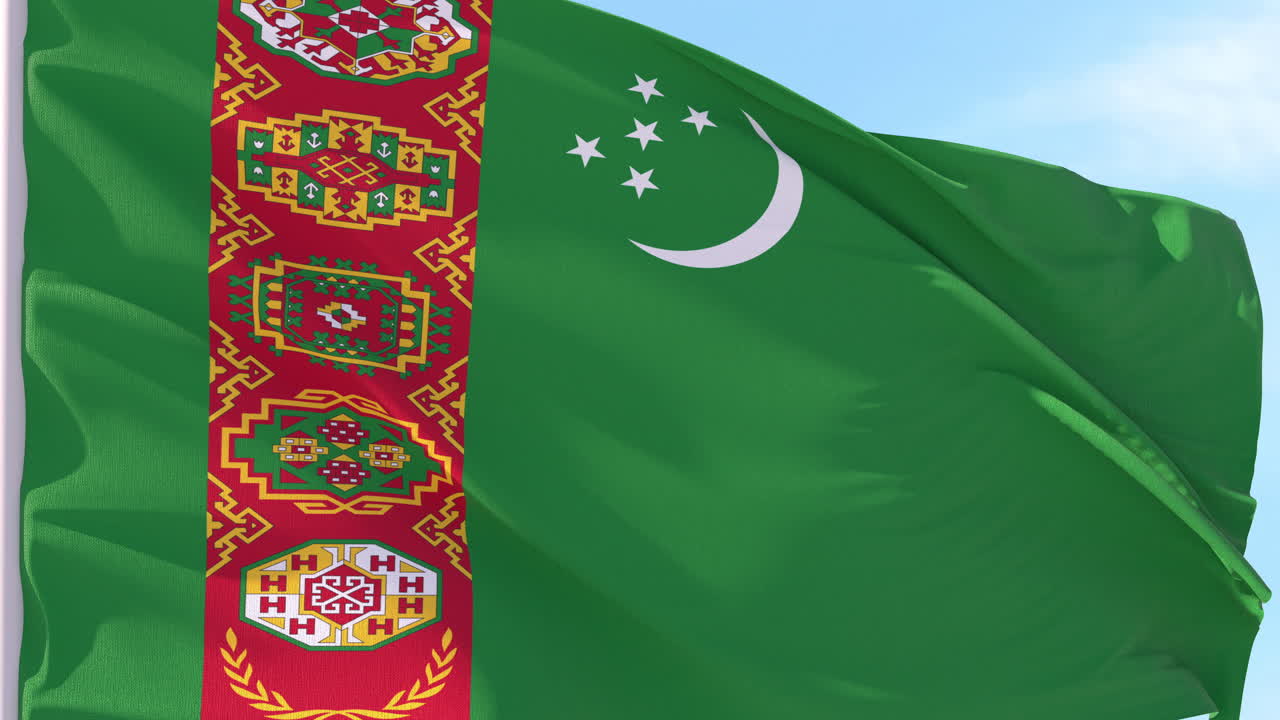 Bandeira do Turcomenistão tremulando ao vento contra o céu azul.