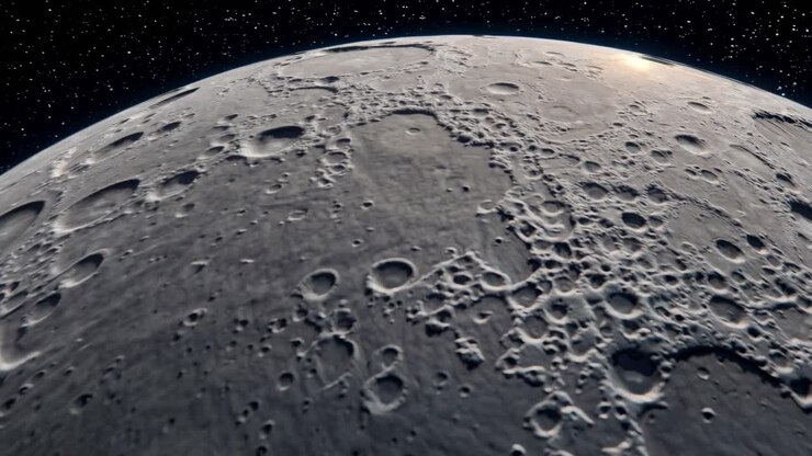Uma imagem estática de vídeo cinematográfica da superfície craterada da lua em perspectiva de baixo ângulo.