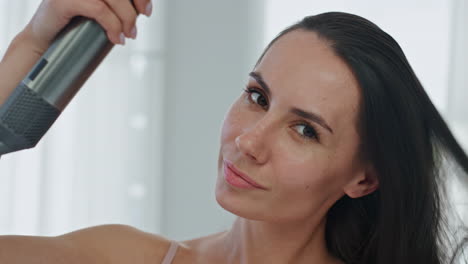 mujer sonriente peinando el cabello usando secador de cabello baño pov video. dama secando chevelure