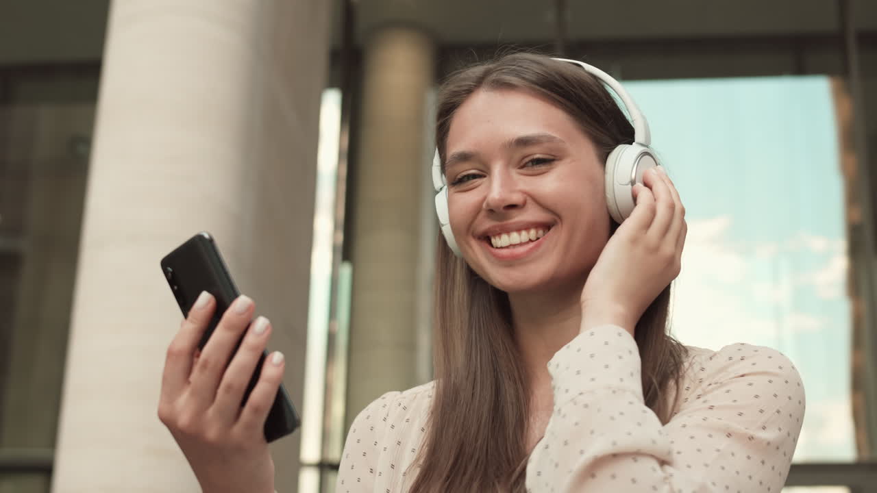 Woman with Smartphone and Headphones Smiling