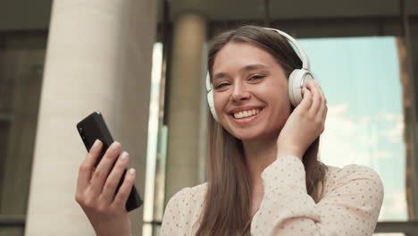 woman with smartphone and headphones smiling