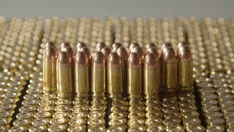 hand grabbing single 9 millimeter bullet from a large collection of ammunition