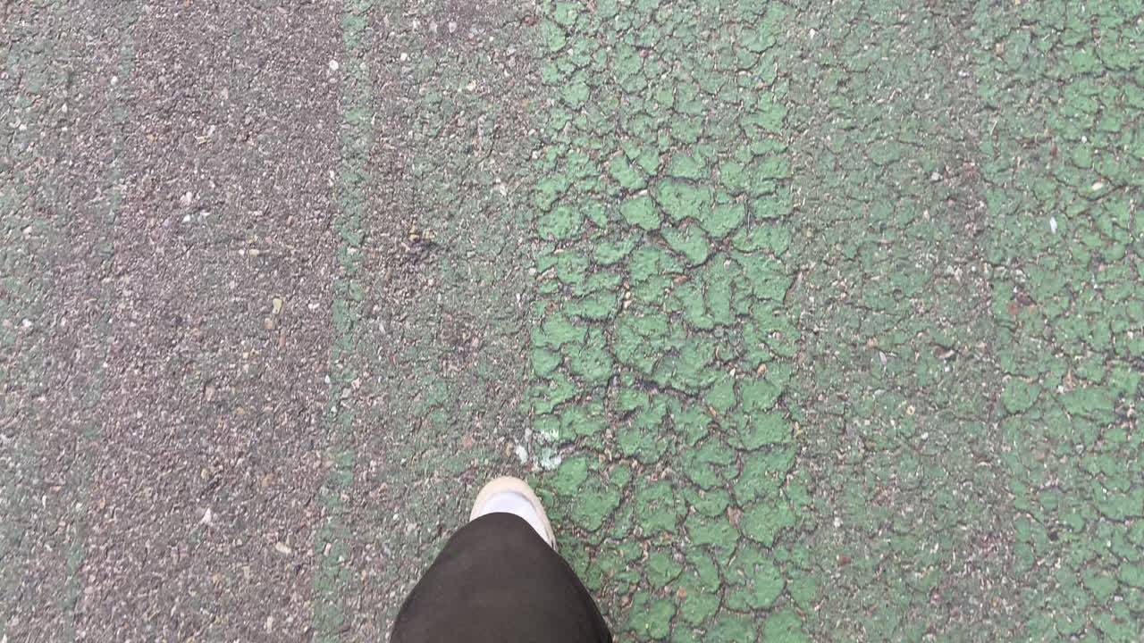 하 스니커와 검은색 바지를 입은 발의 아름다운 이 낮에 교통 표지판으로 파괴된 트랙을 따라 고 있습니다.