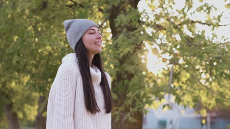 relaxed woman breathing fresh air standing in the park in autumn 2