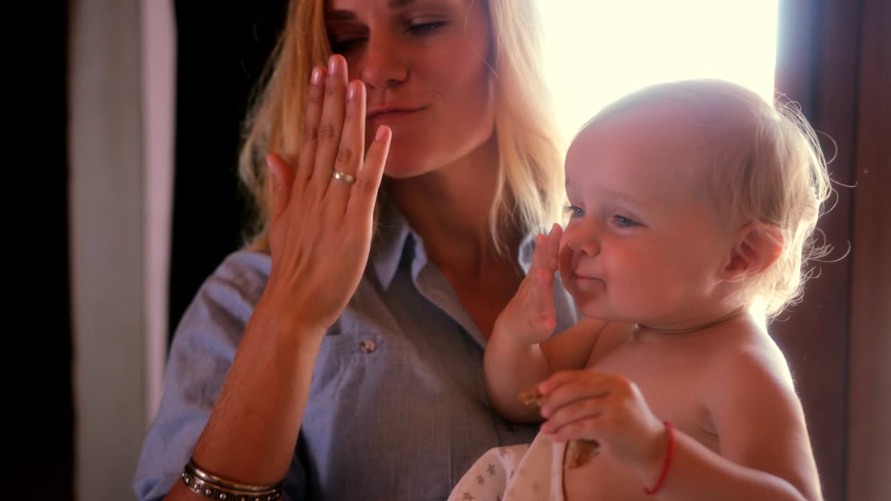 엄마가 손을 흔들고 키스를 는 귀여운 아기